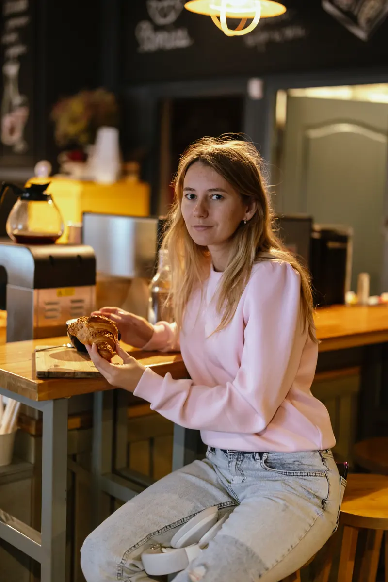 Gäst plockar upp sin take away i en papperslåda på ett café