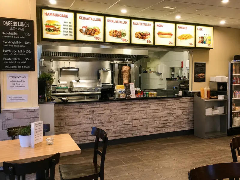 Grillbar med menytavlor, kebabspett och kassadisk