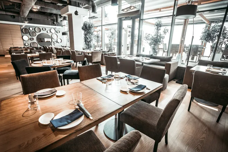 Dukade bord i en ljus restaurang med stora fönster mot gatan