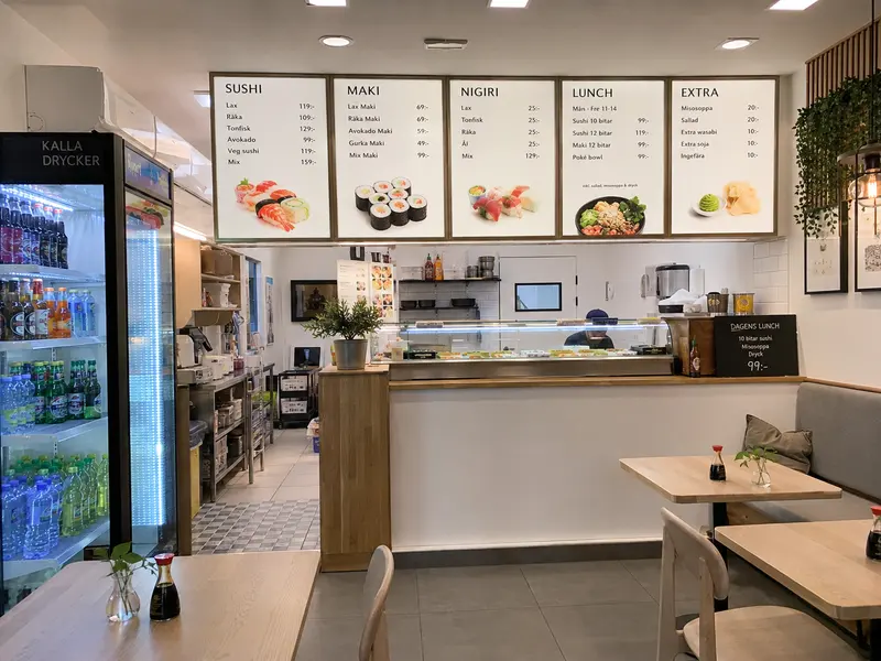 Sushirestaurang med menytavlor för maki, nigiri och lunch ovanför disken