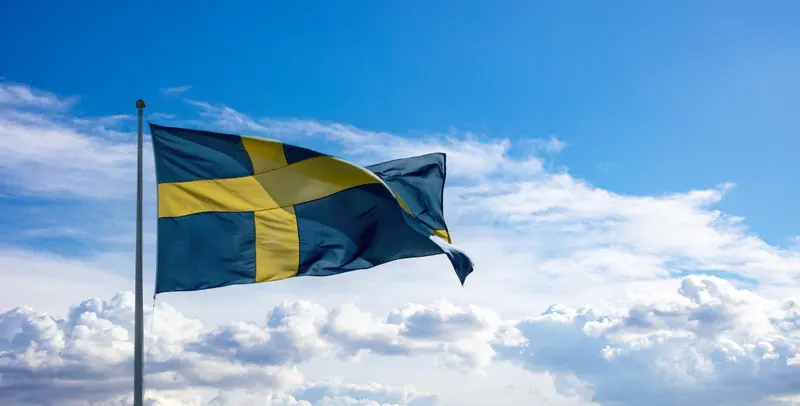Svenska flaggan vajar mot en blå himmel